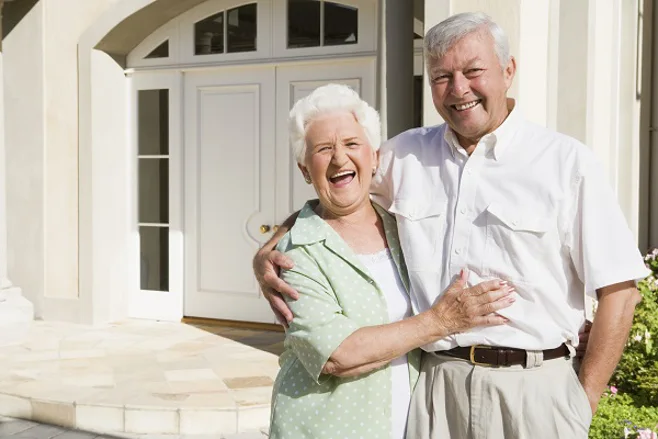 Happy senior couple outside their beautiful home Happy senior couple outside their beautiful home